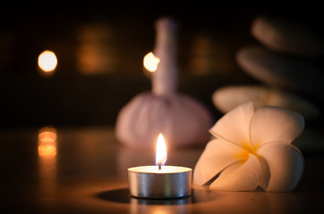 Spa concept: candle, Plumeria, stone with warm light in the dark