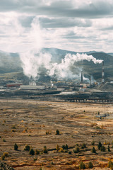 Fototapeta premium The dirtiest city, the factory in nature and the mountains of garbage. Smokestacks of the enterprise, violation of ecology. Coal processing