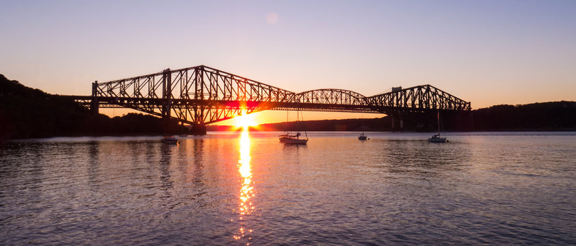 Canada - Vertical Sunset Behind The Old Quebec City Bridge - Sun Reflection Over The Water Of A Small Marina.