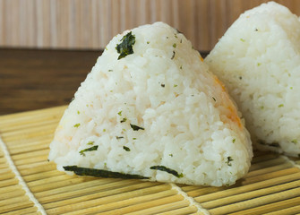 The Japanese food Onigiri  white rice formed into triangular or cylindrical shapes and often wrapped in nori.
