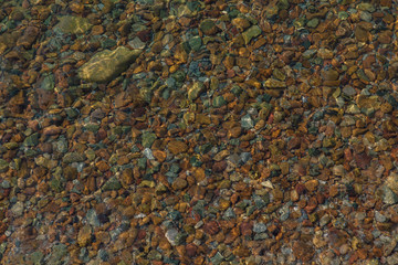 Background of colorful stones under the sea water.