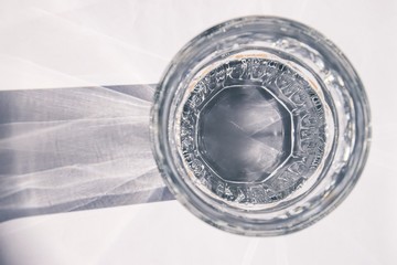 light shining through a glass of water with white background
