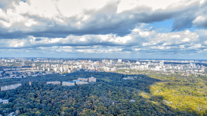 Aerial view of the city. Show of autumn foliage around the fields and forest