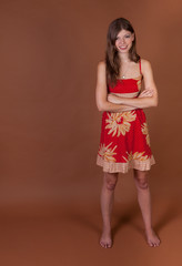 Full length shot of a barefoot  naturally thin healthy brunette girl in the studio with a brown background