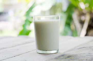 A cup of cows milk on the table, natural background