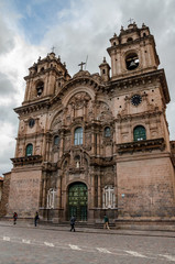 Fototapeta premium Cusco, Peru - January 1, 2017: Facade of the Temple of the Company of Jesus with some clouds on top, in front of the main square of Cusco, Peru