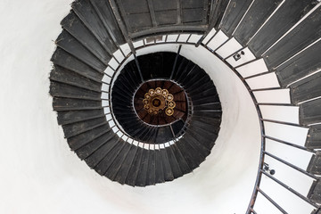 Fototapeta premium Spiral staircase in vintage style. Low angle stair with old chandelier.
