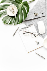 Home office workspace mockup with tropical leaves Monstera, clipboard, notebook and accessories on white background. Flat lay, top view