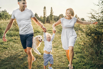 Young happy family with dog have fun outdoor