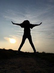 Fototapeta na wymiar Silhouette of a young woman stood on Ilkley Moor, Yorkshire, England