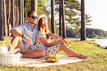 Beautiful couple enjoying picnic time on the sunset