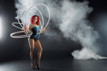 beautiful female red hair circus artist holding hoops