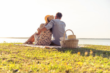 Beautiful couple enjoying picnic time on the sunset