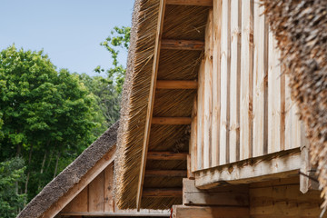 Naklejka premium Wooden cottages with straw roof.