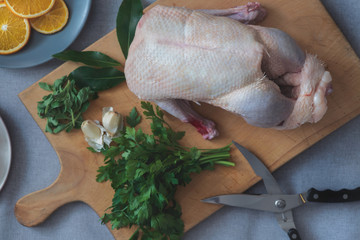 Ganze Barbarie Ente zu Weihnachten zum Essen mit Kräutern auf einem Holzbrett