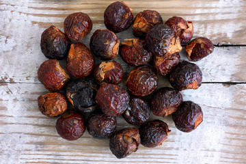 Heap of soap nuts on wooden background.