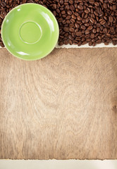 coffee beans and saucer on wooden background