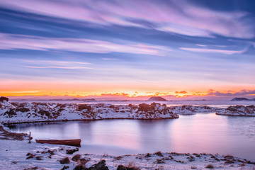 Vivid sunset over lake Myvatn, Iceland with sky of Mother of Pearl (Nacreous ) clouds over frozen...