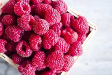 Ripe raspberries in a wooden box.