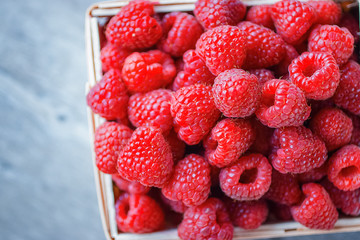Ripe raspberries in a wooden box.