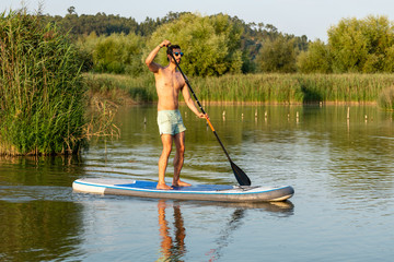 Fototapeta na wymiar Man stand up paddleboarding