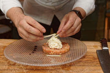 Obraz na płótnie Canvas Chef is decorating salmon tartar with apple