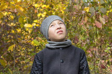 looking up the boy in autumn,boy in a gray coat in autumn with a neck collar