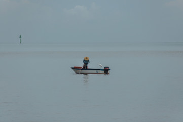Fisherman and a heron are fishing