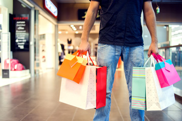 Cropped image of handsome man with shopping bags doing shopping in the mall