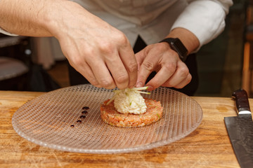 Obraz na płótnie Canvas Chef is cooking salmon tartar with cut apple