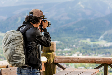 Photographer from behind shoot  the Zakopane and Tatra Mountains from Gubalowska. Zakopane is the Winter Capital of Poland