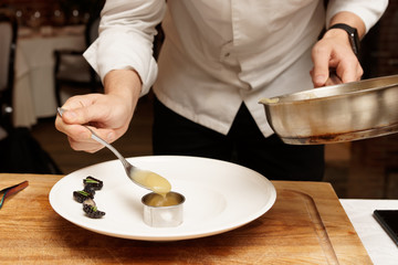 Chef is putting puree to plate