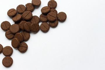 Few brown detox pills on white background