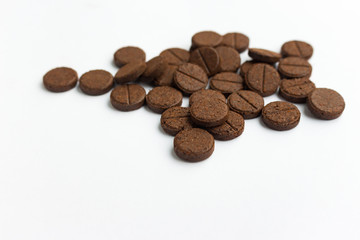 Few brown detox pills on white background