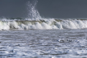 Foamy splash of a tube wave in the rays of the early morning sun