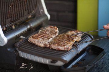 Meat on an electric grill. Home cooking. Healthy barbecue. Catering to friends. Electric grilling