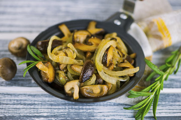 fried Japanese mushrooms shiitake with onions and spices in a frying pan