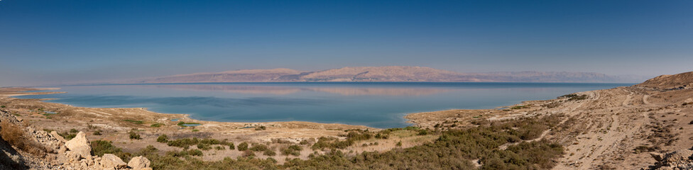 Fototapeta na wymiar Panoramic landscape of Dead Sea and Jordan mountains in middle day. Israelian border coastline