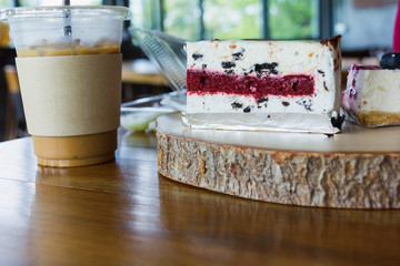 Woman use spoon to scoop blueberry cake from chopping block in cafe