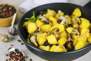 fried potatoes with Japanese shiitake mushrooms and onions in a frying pan