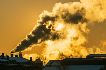 The vapor thick from the cold and illuminated by a huge low sun rising above the historical center of St. Petersburg