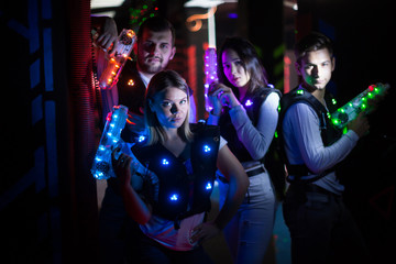 Young people in laser tag labyrinth - obrazy, fototapety, plakaty