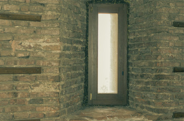 Door in niche of old brick wall