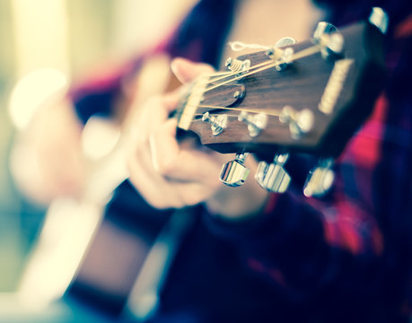girl holding guitar. Focus on the head of guitar