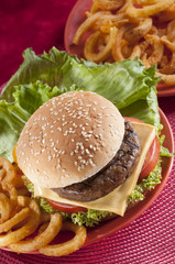 Beef Burger with bell pepper and lettuce with cherry red and yellow tomato on Red background 