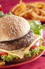 Beef Burger with bell pepper and lettuce with cherry red and yellow tomato on Red background 