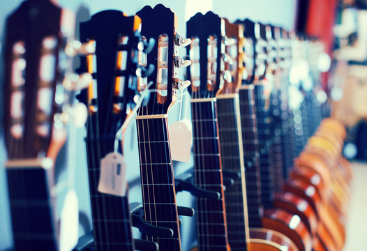 line of heads of acoustic guitars