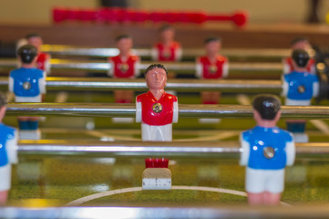 Fototapeta premium Red and white uniform table soccer player figurine on foosball board