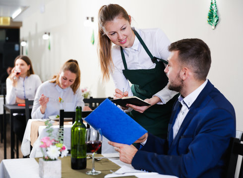 Businessman is giving order to female waiter in luxury restaurante