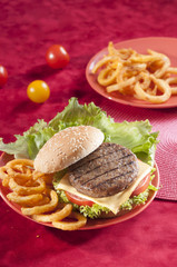 Beef Burger with bell pepper and lettuce with cherry red and yellow tomato on Red background 